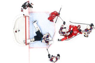 Top-down view of ice hockey goal and players