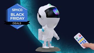 An Astronaut Galaxy Projector, with a hand holding a small remote and a logo reading Space Black Friday Deals.