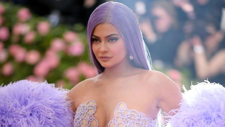 Kylie Jenner wears an all purple outfit to match her purple hair as she walks the red carpet.