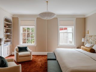 A bedroom with a muted scheme, with a bright orange carpet