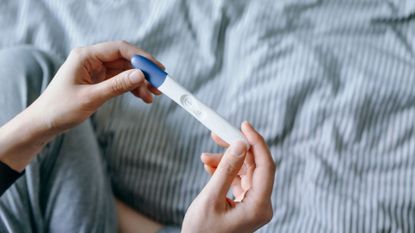 Woman who is struggling to conceive holding a pregnancy test 