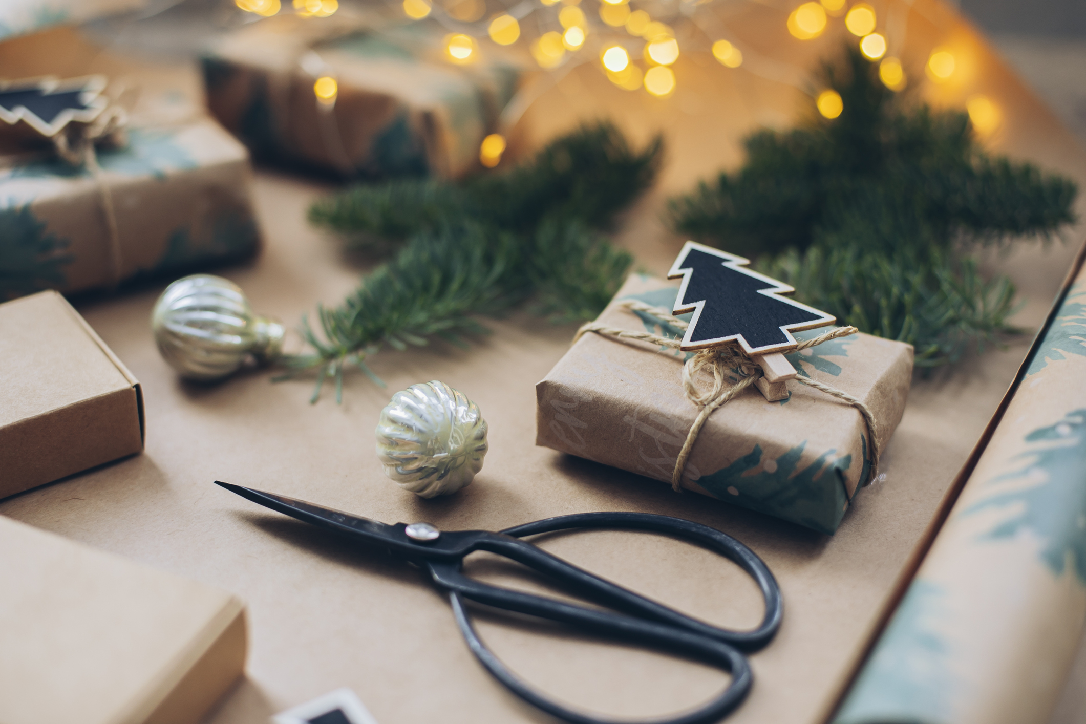 Christmas background with gift box, scissors, fir tree branch, wrapping paper roll