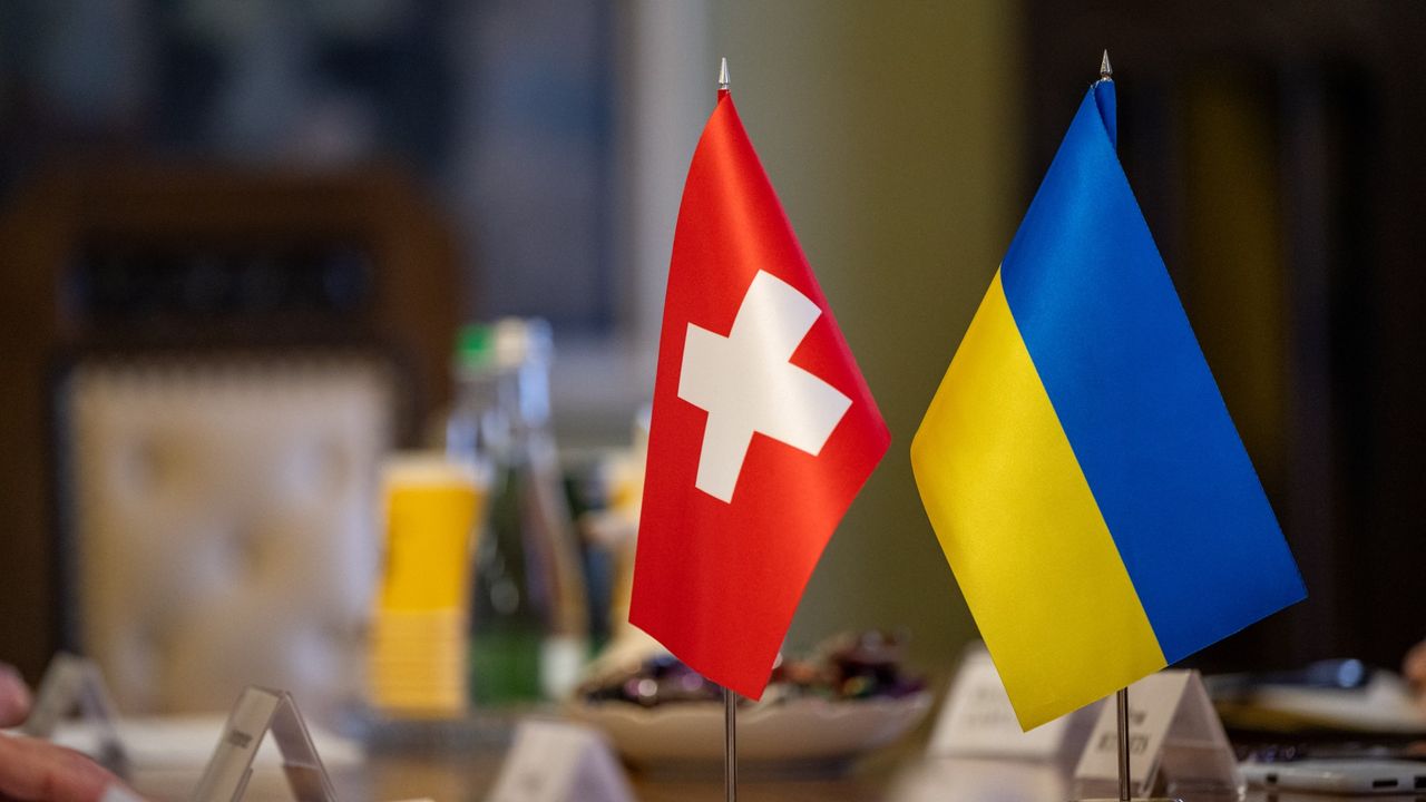 A pair of Swiss and Ukrainian flags in Lviv, Ukraine.