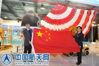 A recent ceremony in China showcased the automated re-entry capsule that flew a circumlunar trajectory and returned to Earth under parachute. The capsule housed various items, including the Chinese flag.