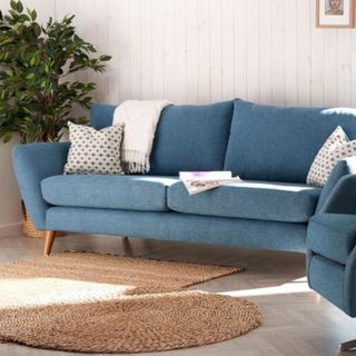 a blue sofa in a neutral living room