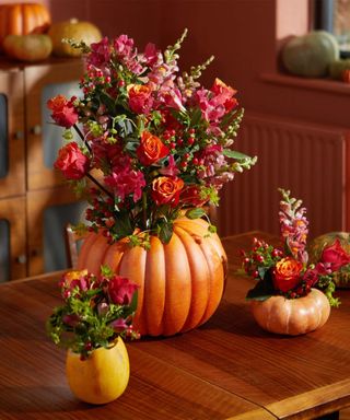 pumpkins carved into vases and filled with fresh flowers