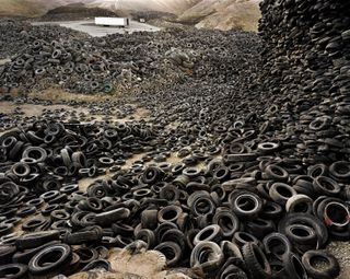 Photograph of discarded car tyres in a landfill