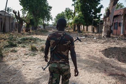A Nigerian soldier patrols an area attacked by Boko Haram