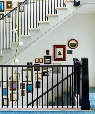 staircase with blue carpet and picture gallery