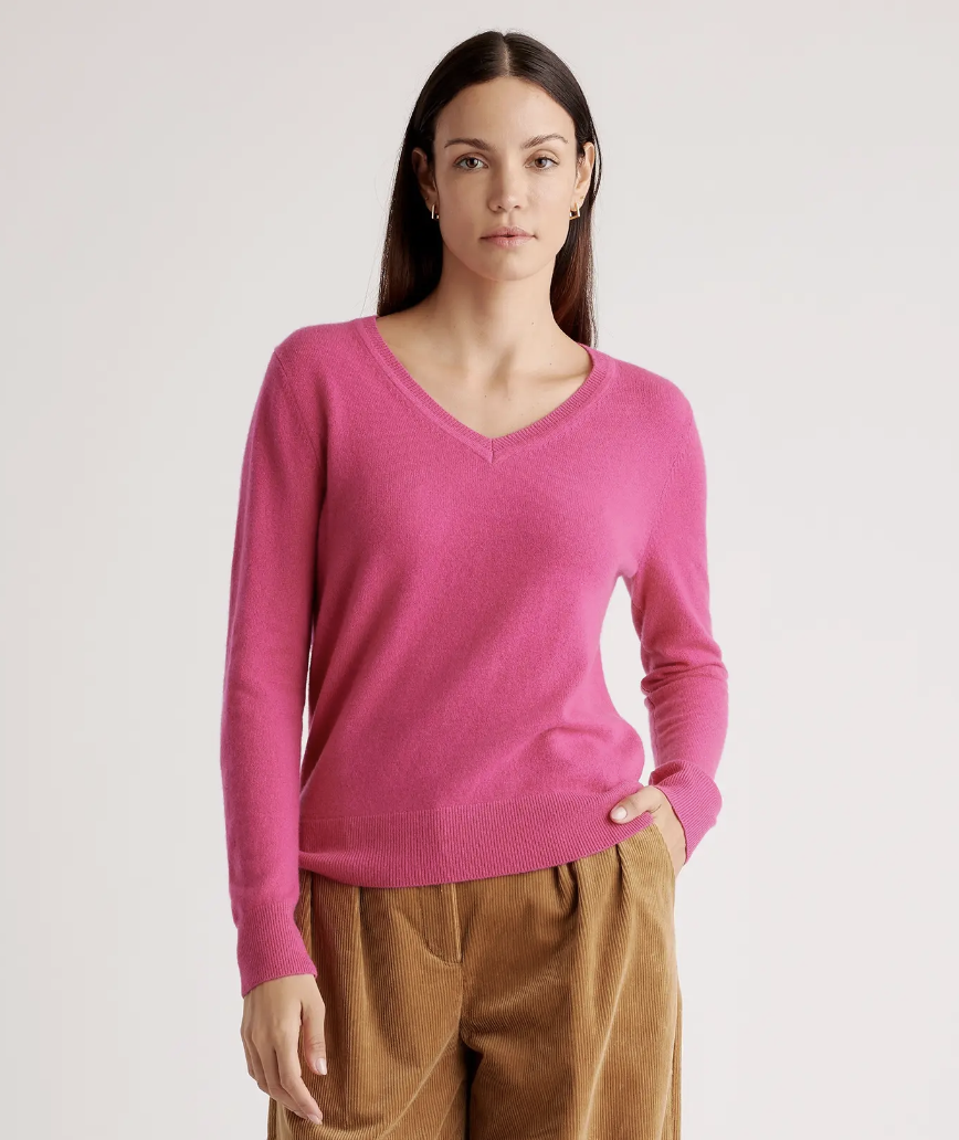 A woman wears a raspberry colored Quince cashmere sweater