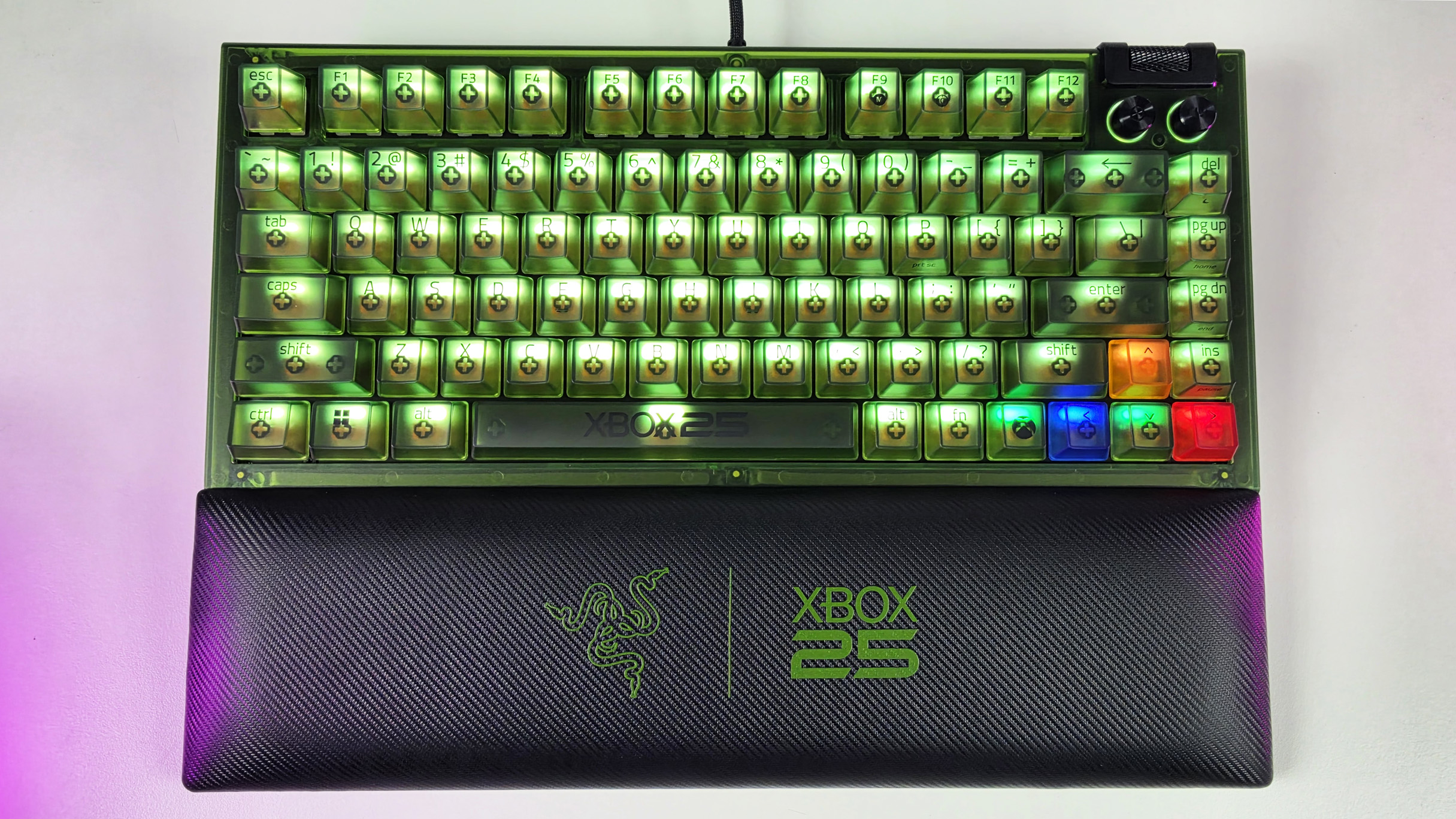Top-down view of the Razer BlackWidow V4 75% Xbox 25th Anniversary keyboard illuminated with RGB lighting and attached matching wrist rest.