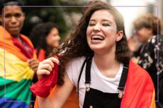 Tween with braces smiling wrapped in rainbow flag