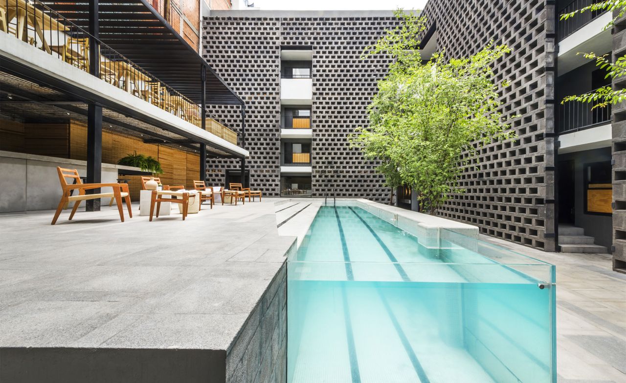 Outside pool area, pool is contained above ground section with glass, feature walls using cinder blocks