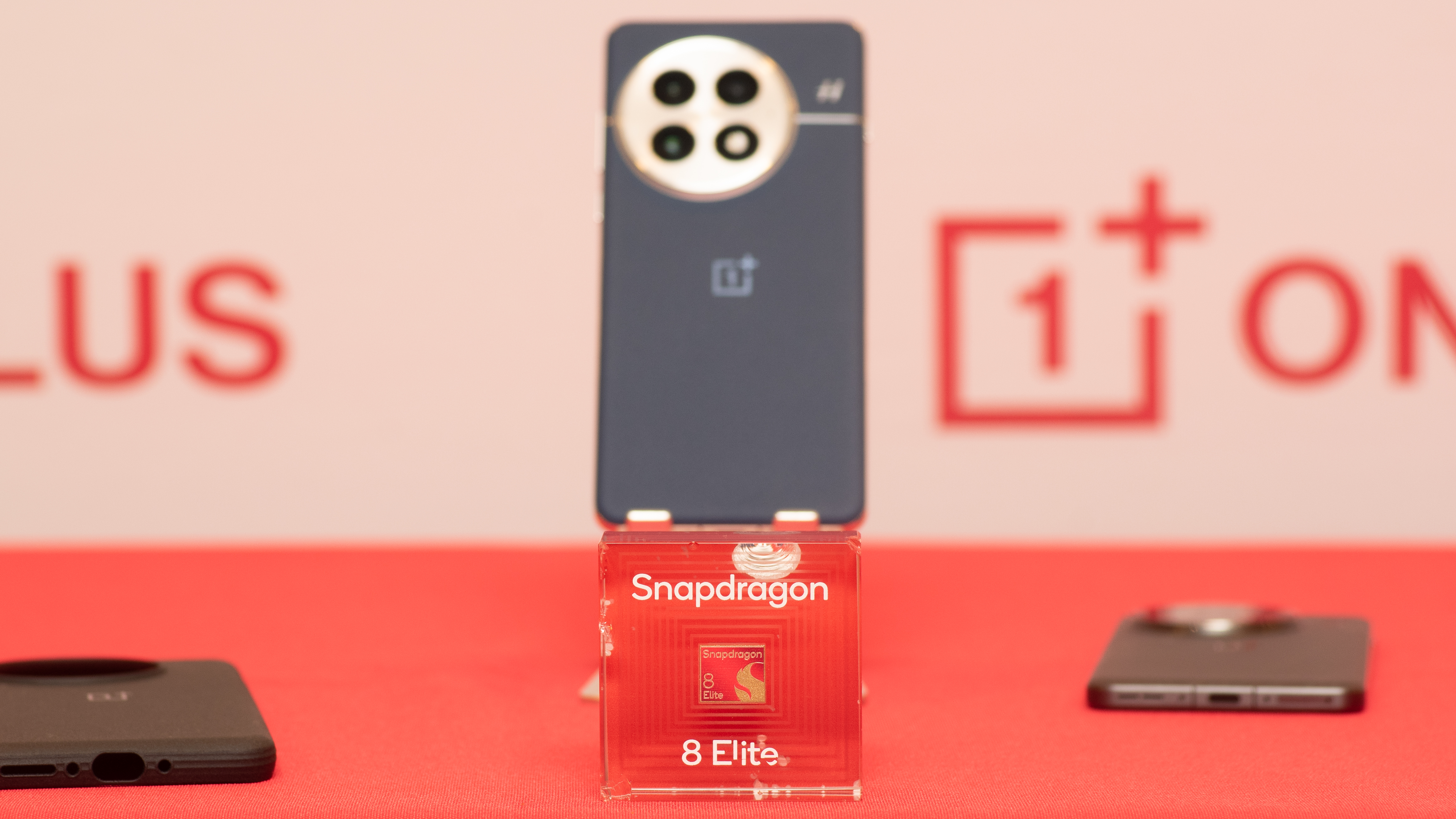 OnePlus 13 with Snapdragon 8 Elite plaque and mock-up processor in foreground