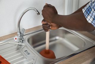 unblocking a sink with a plunger