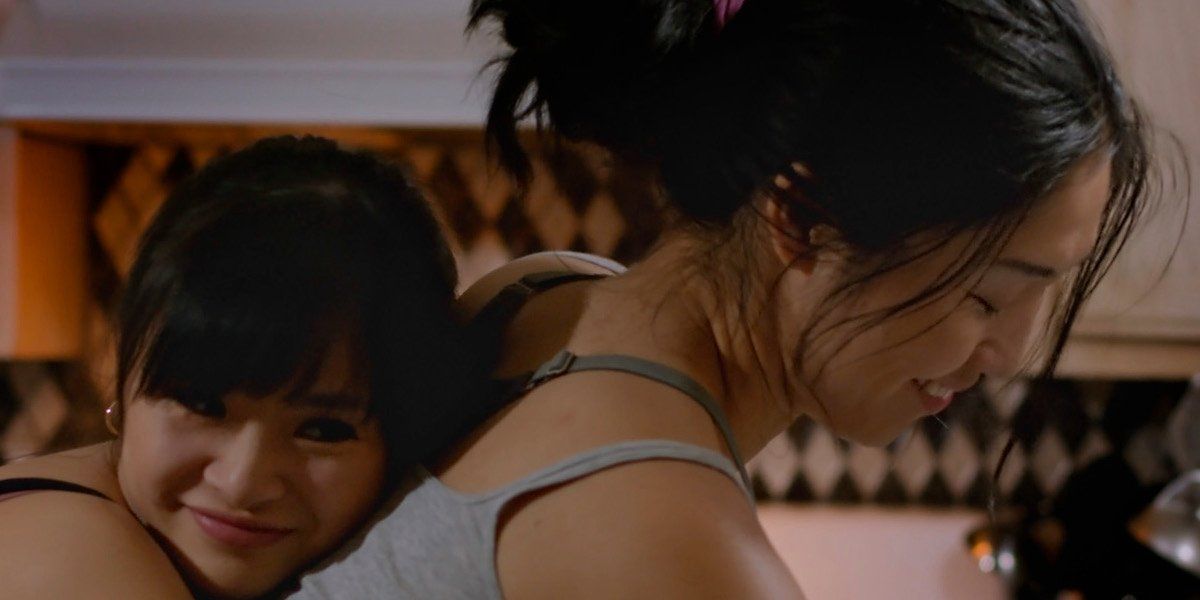 Hedy Wong (as Tera) embraces Lynna Yee (as Tera&#039;s mother Wavy) from behind as Lynna cleans in Take Out Girl