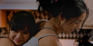 Hedy Wong (as Tera) embraces Lynna Yee (as Tera's mother Wavy) from behind as Lynna cleans in Take Out Girl