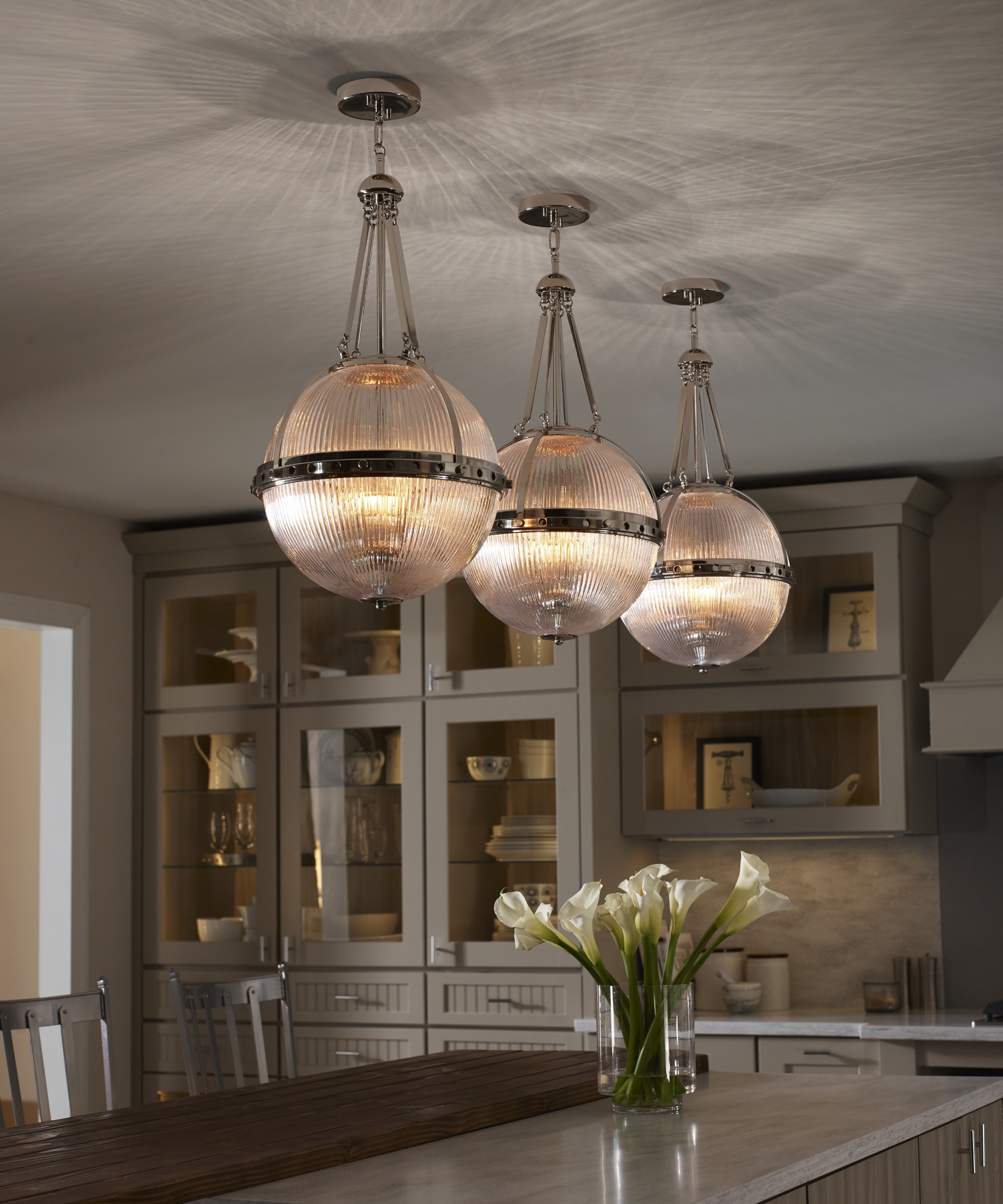 fluted glass and chrome sphere pendant lights suspended above kitchen island