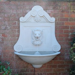 white coloured classic cast stone water feature on wall