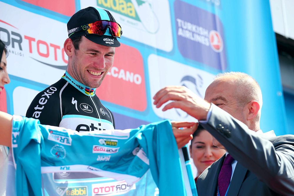 Cavendish puts on the blue race leader's jersey.