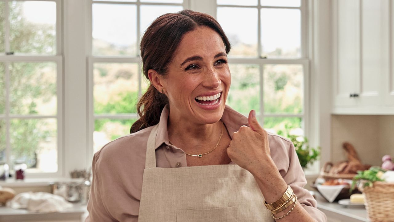 Meghan Markle wears a pink shirt and neutral apron in a still from Netflix show With Love, Meghan