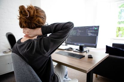 Work from home posture: A woman clutches her neck in pain