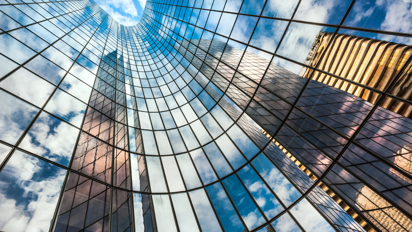 Reflection of blue sky on building glass windows with curve lines.