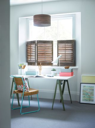 half shutters in home office next to desk