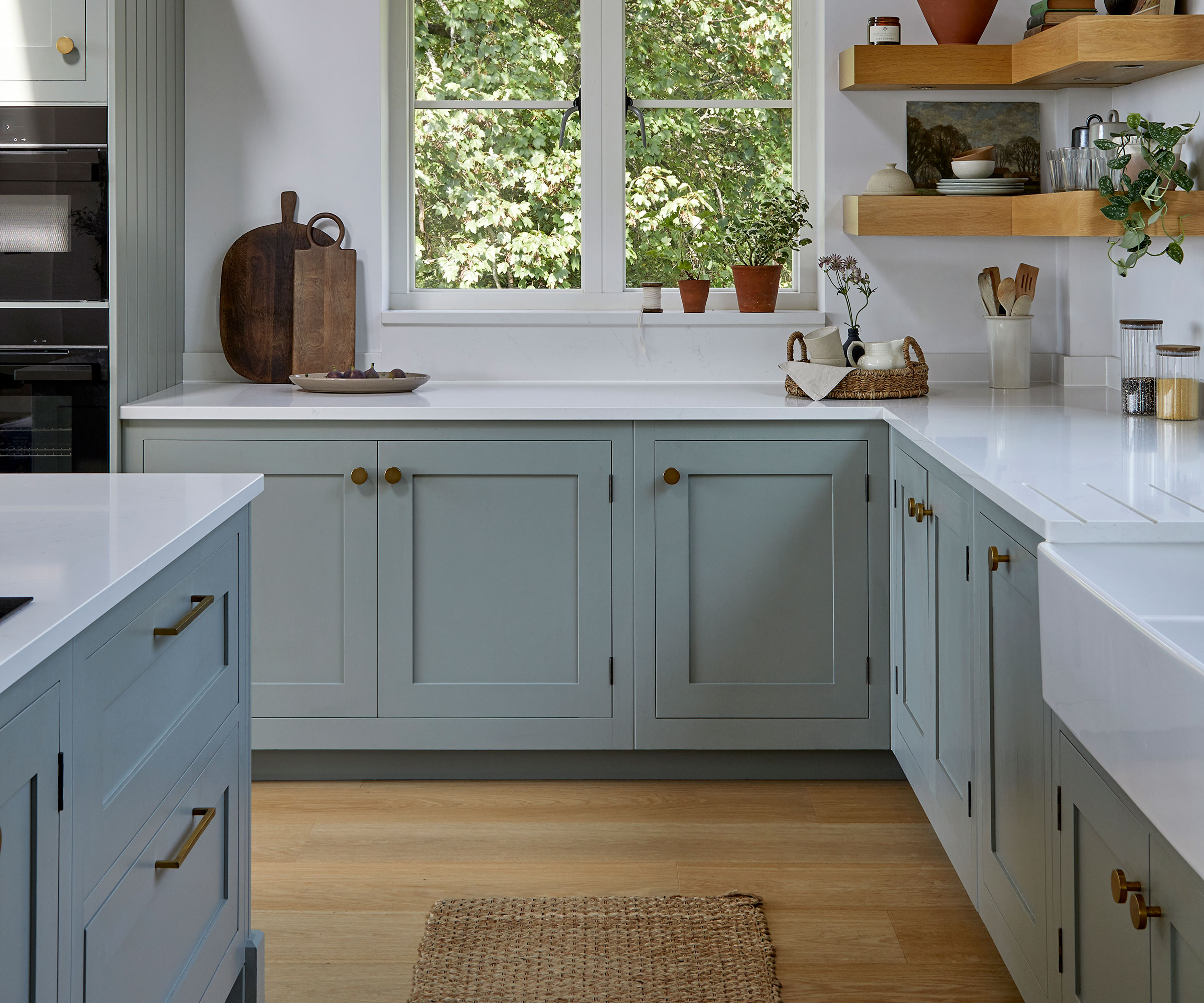 pale blue Shaker kitchen with wooden knobs and white worktops