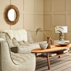 Living room with beige panelled walls and beige sofas