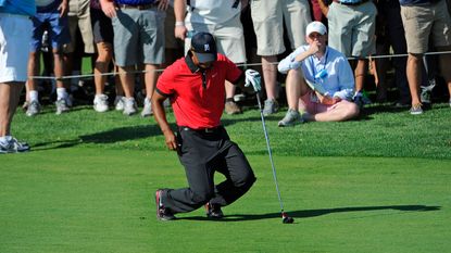 Tiger Woods falls to the ground in pain after hitting his second shot on the 13th hole during the final round of The Barclays in 2013