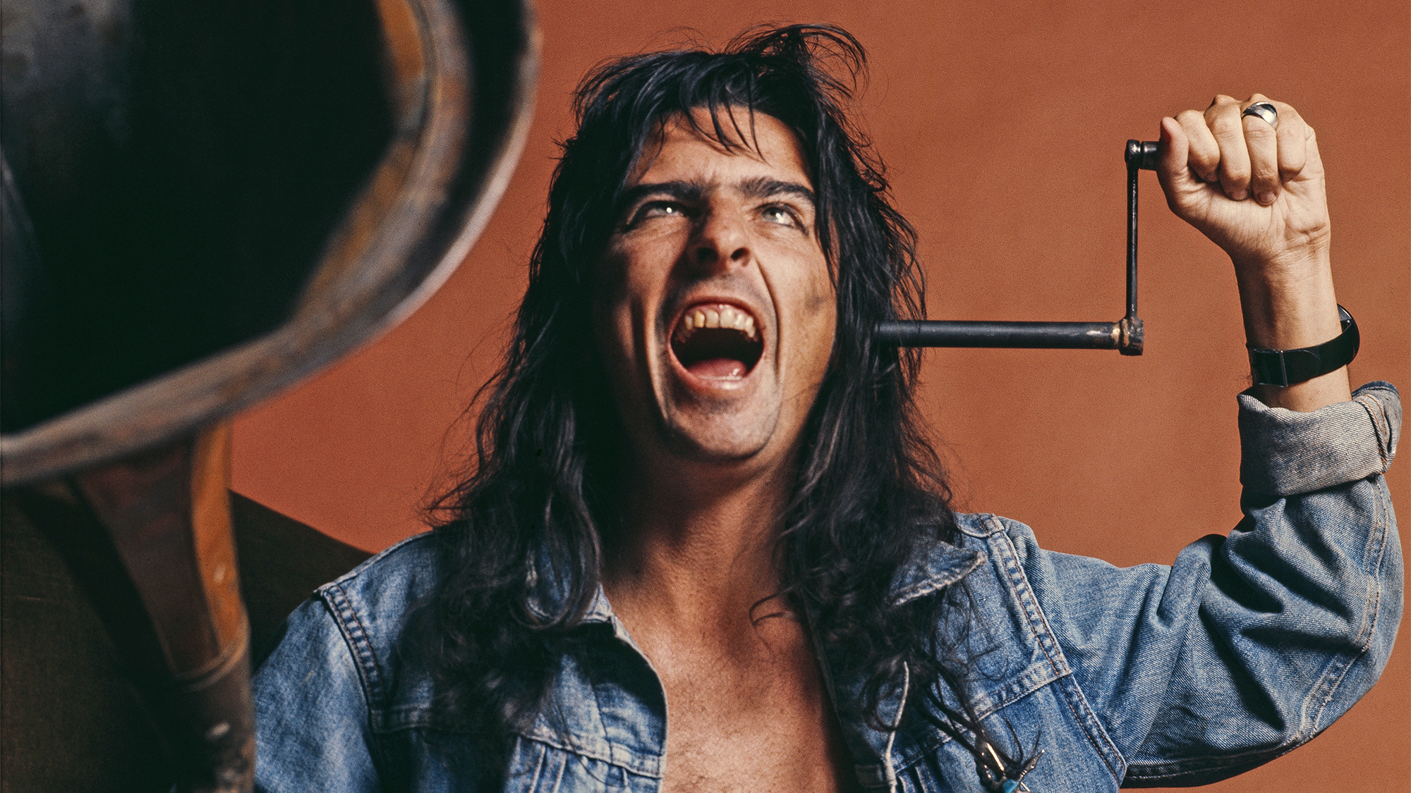 American rock singer-songwriter Alice Cooper listening to a vintage phonograph, London, March 1974. 
