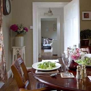 dining room with wooden flooring and round antique table and chairs