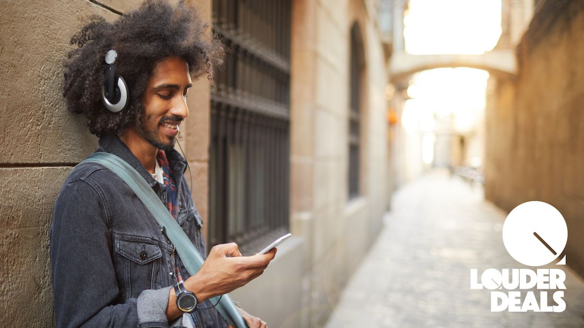 Man stands in the street listening to music on his phone