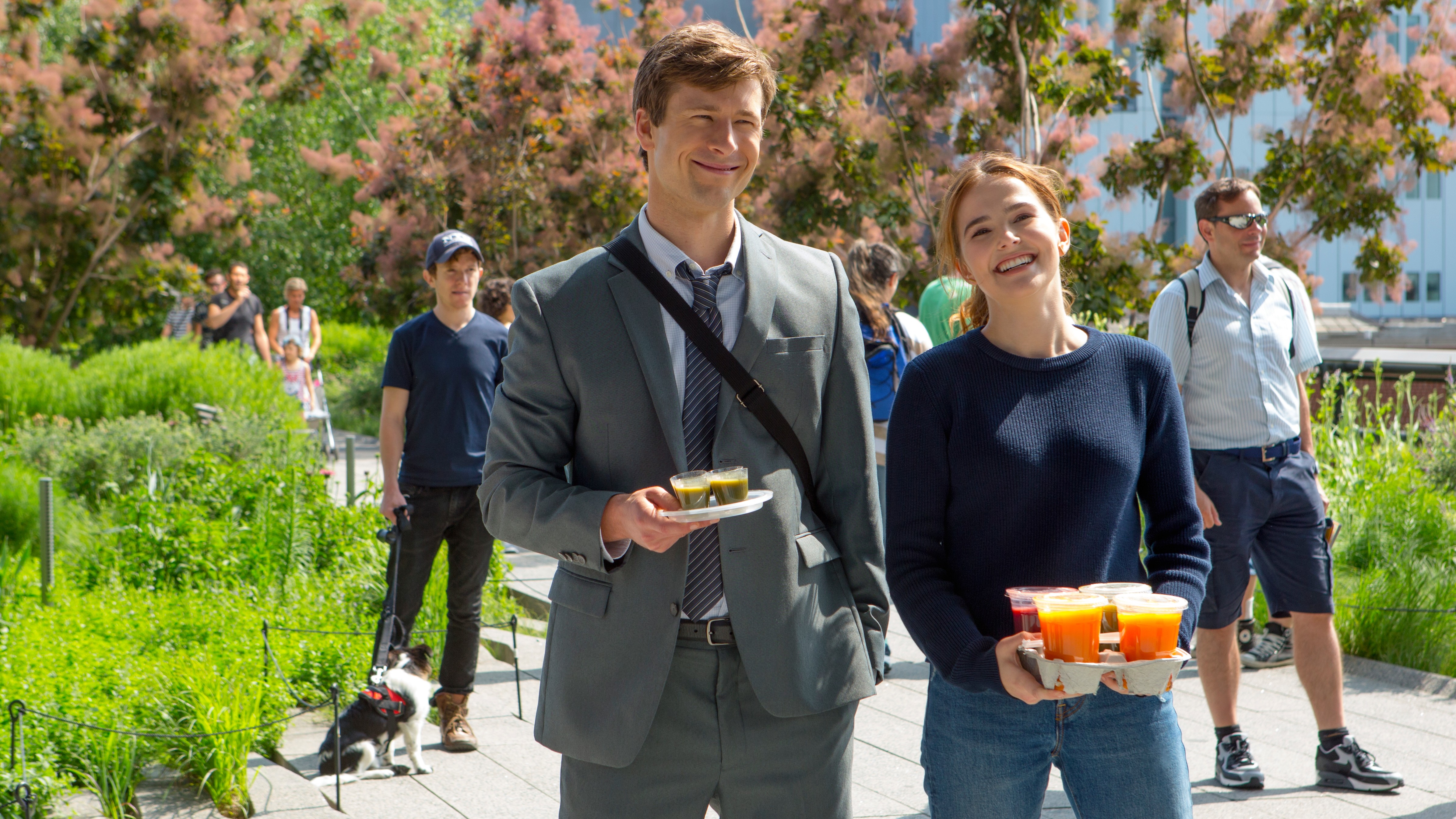 L-R: Charlie (Glen Powell) and Harper (Zoey Deutch) walking through a city together in a scene from Netflix's "Set It Up"