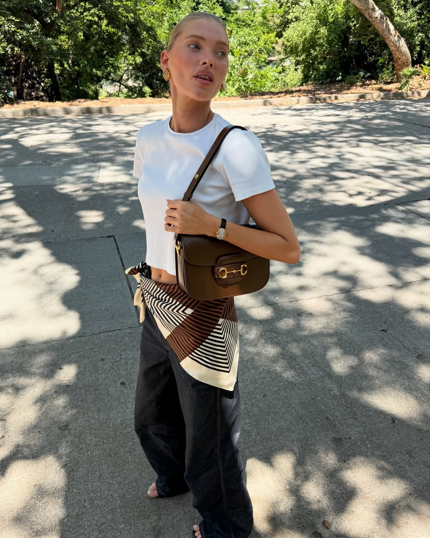 woman wears brown gucci horsebit bag