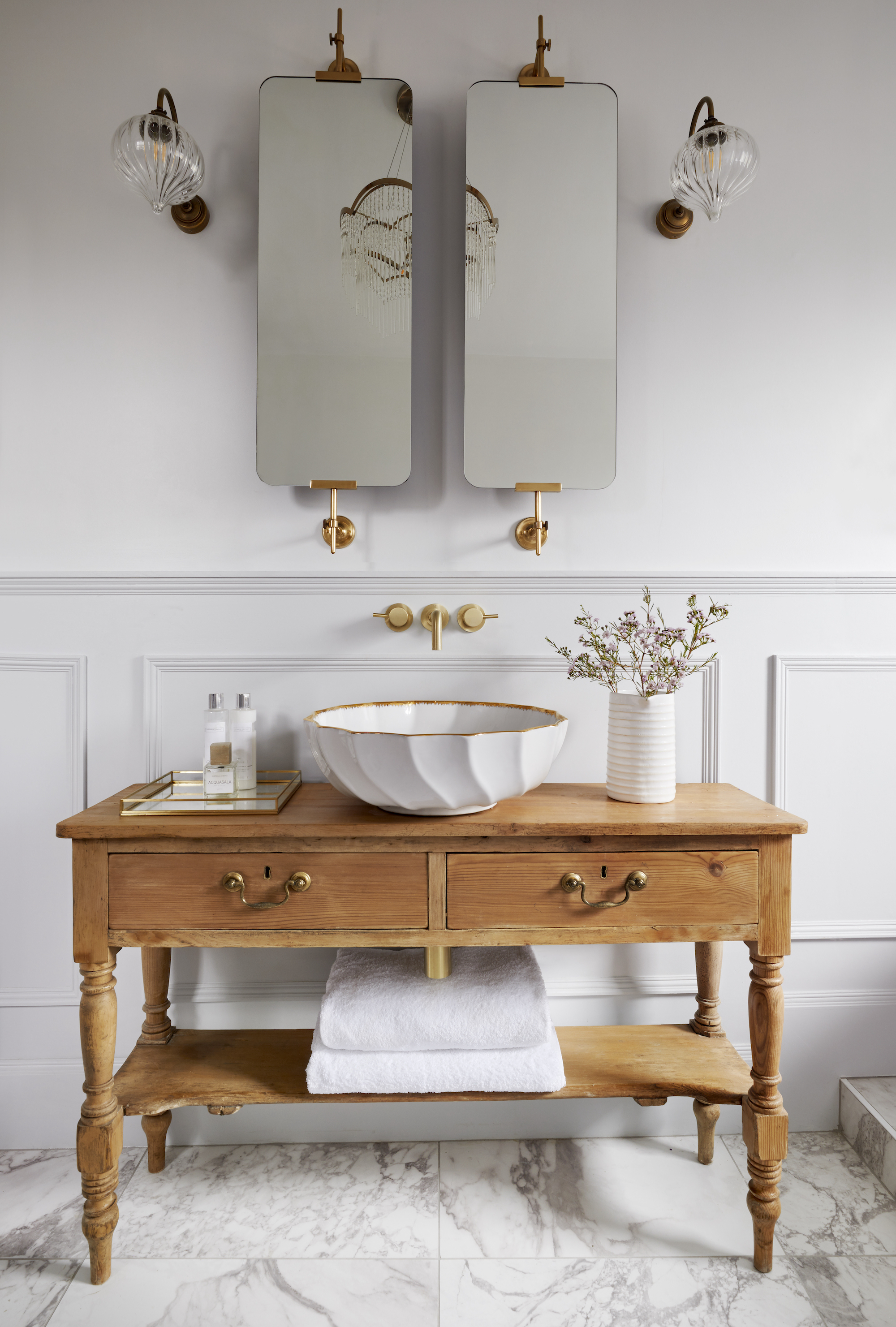 white bathroom with panelling, double mirrors, vintage vanity unit, white basin, wall lights