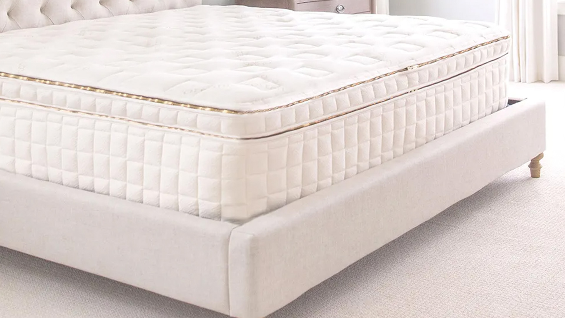 An EOS Naturepedic pillow top mattress on top of a white bedframe