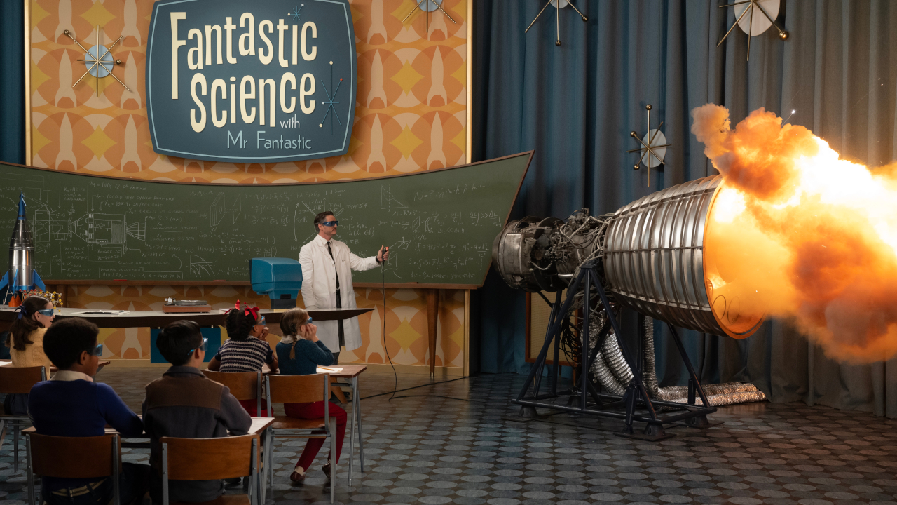 Pedro Pascal observes a lit rocket booster while eager children watch on in The Fantastic Four: First Steps.