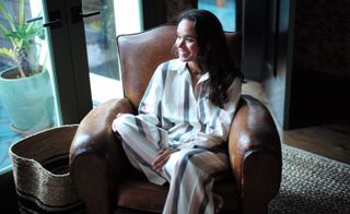 Woman on leather arm chair in pyjamas