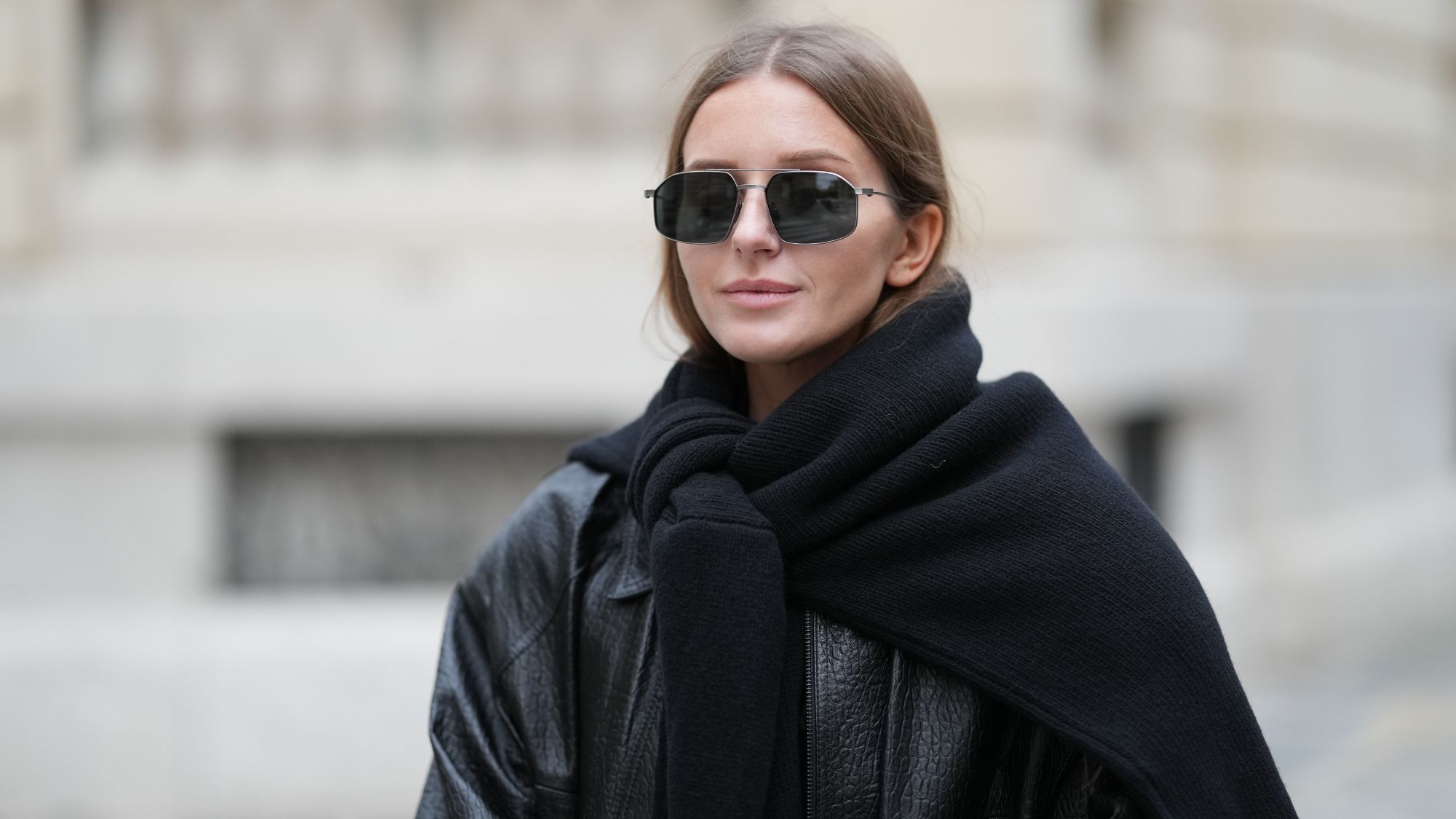 street style shot of woman wearing sunglasses and black jacket