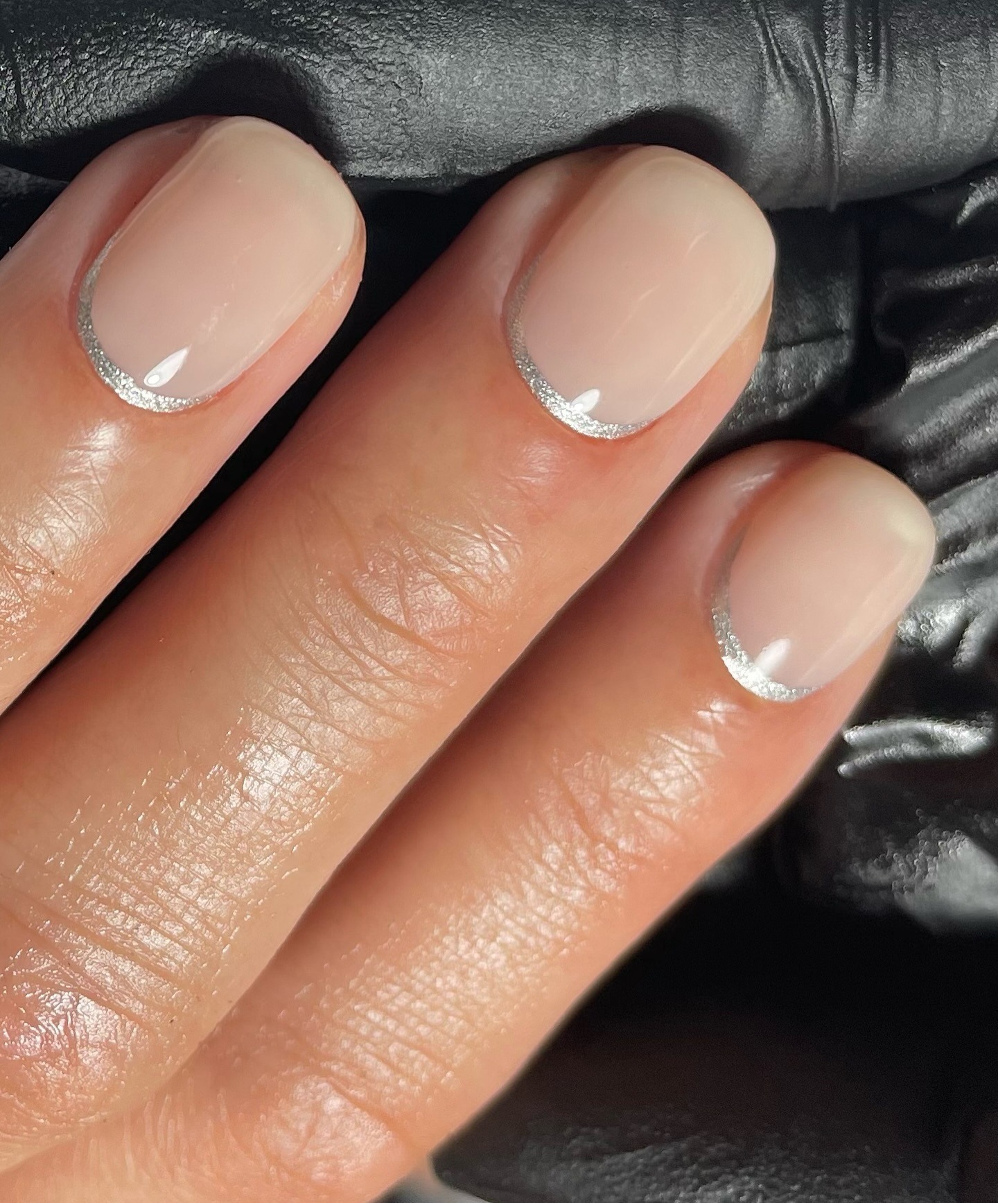A silver reverse French tip short manicure
