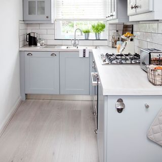 white kitchen with laminated wooden flooring