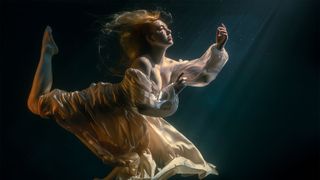 A portrait of a model in a glass tank, creating the illusion of an underwater image 