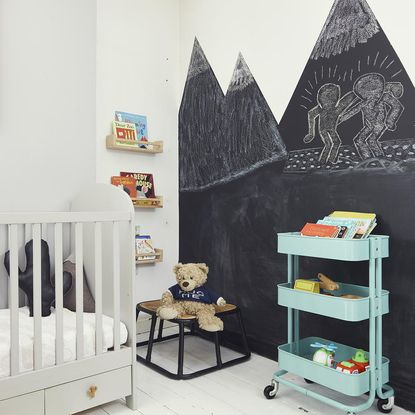 kids bedroom with wooden flooring and black board paint on wall