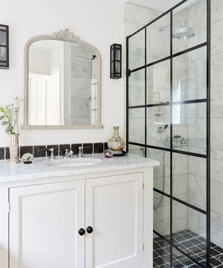 White cabinet, black and white tiled shower