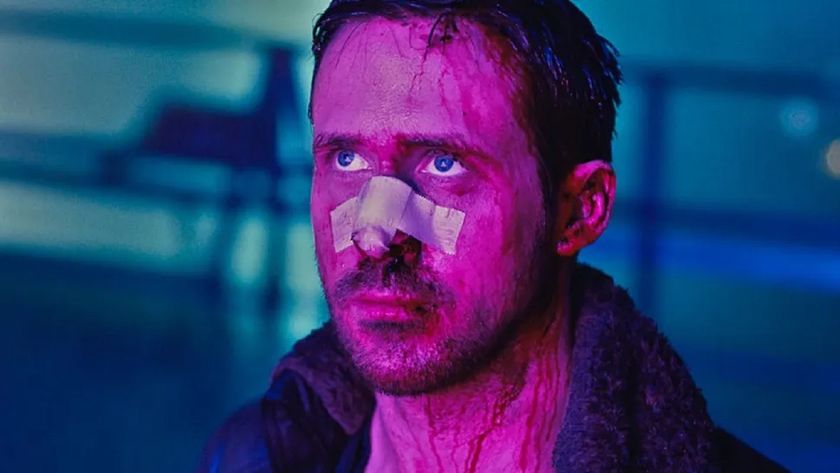 Ryan Gosling in Blade Runner: 2049, his face cut up and with a bandage over his nose, bathed in purple light with the blackground a blurry blue