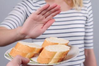 A person turns down some bread that is offered.