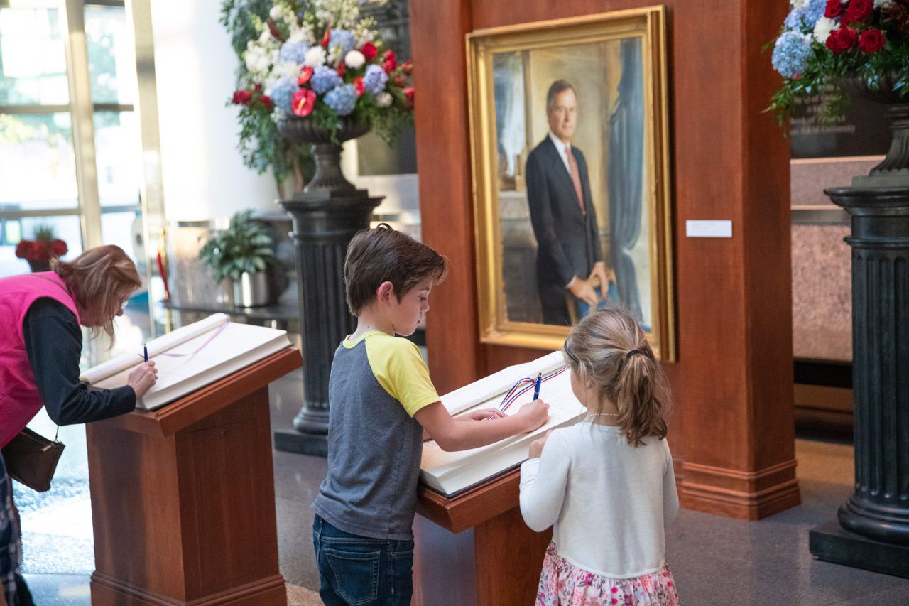 Mourners sign a remembrance book the George Bush Presidential Library on December 1, 2018 in College Station, Texas. 