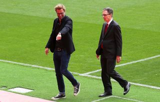 Liverpool manager Jurgen Klopp and principal owner John W Henry walk on the pitch at Anfield